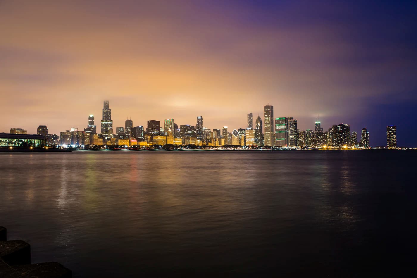 El horizonte de Chicago a la hora dorada, reflejado en la orilla del lago.