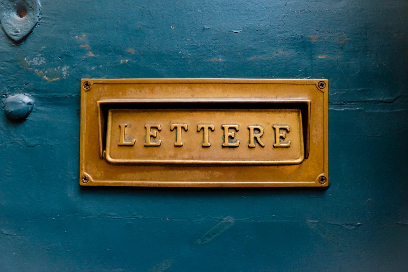 Una ranura de latón para cartas en una puerta pintada.