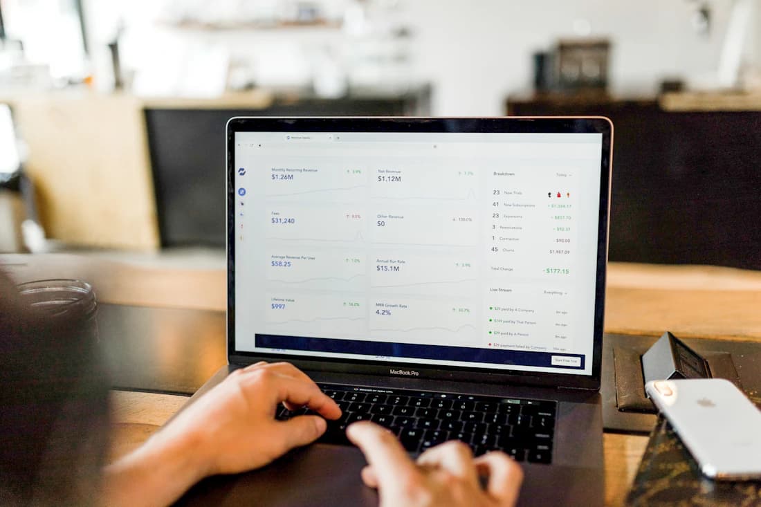 Manos en una laptop revisando un panel de ventas del vendedor.