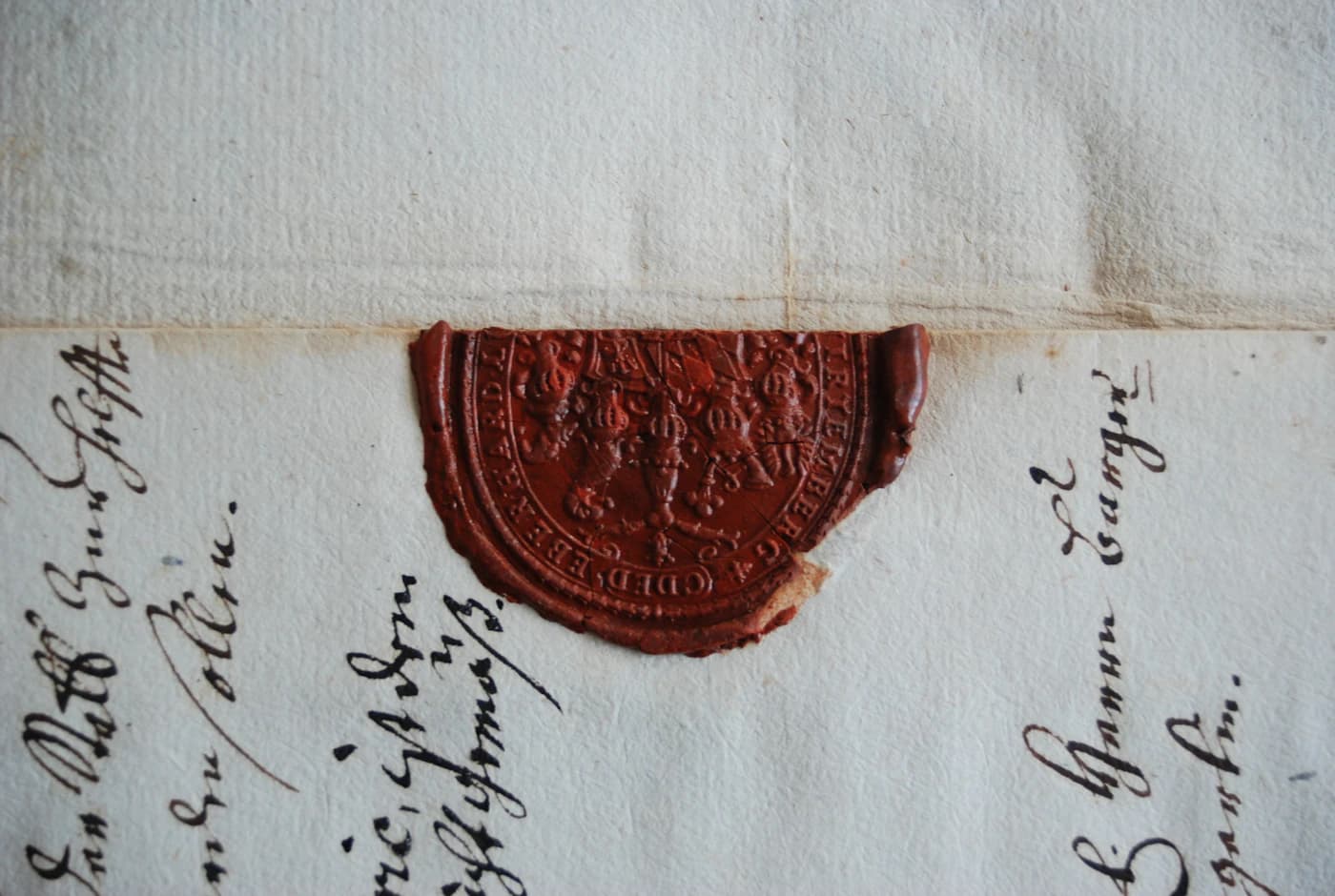 Un sello de cera roja sobre un documento oficial manuscrito.