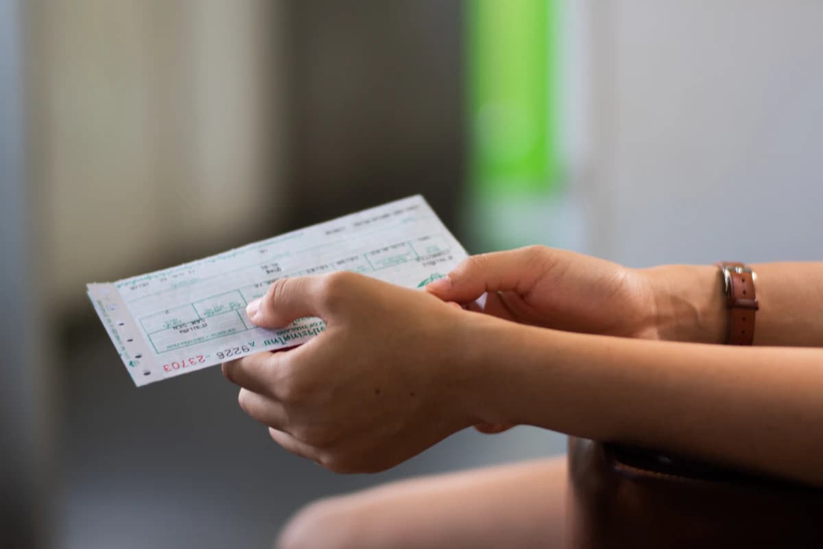 Un cheque de pago impreso sostenido en la mano, lo que el empleado recibe al cierre del ciclo.